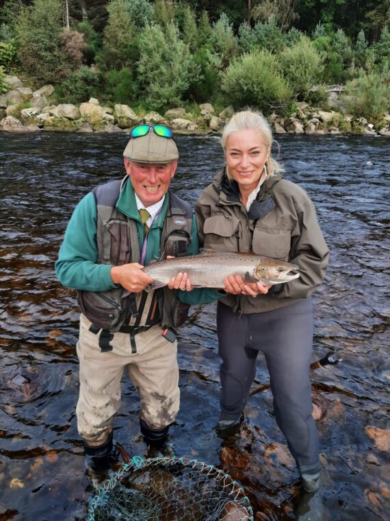 Happy angler with her fish, alongside Head Ghillie Ian Tennant
